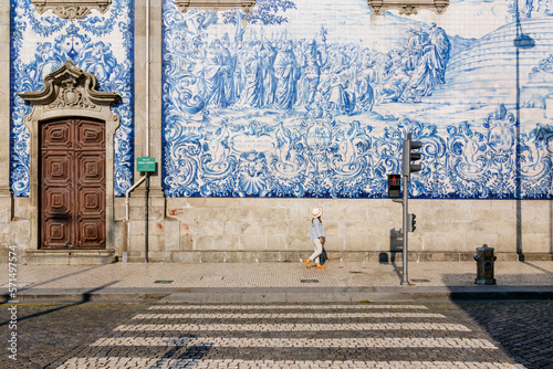 Tourist walking, azulejos tiles over Chapel Of Souls, Porto, Portugal photo