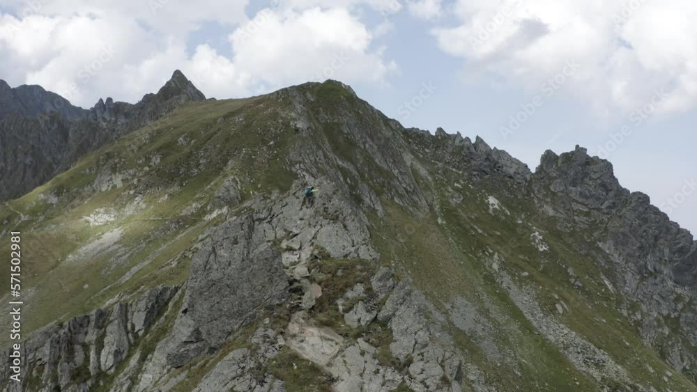 Man climbing natural rocky wall with epic view in the background Man climbing natural rocky wall with epic view in the background
