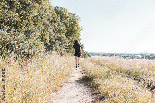 young woman hiking on a path in the middle of the forest © Cavan
