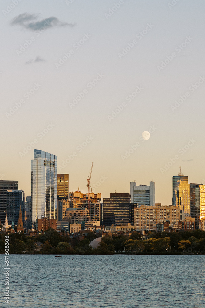 Obraz premium full moon over boston skyline at sunset charles river foreground