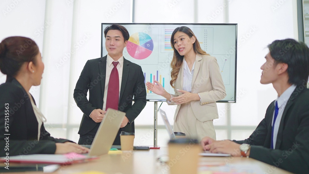 Two business professionals, Asian man and women make presentations in meeting room at office Two business professionals, Asian man and women make presentations in meeting room at office