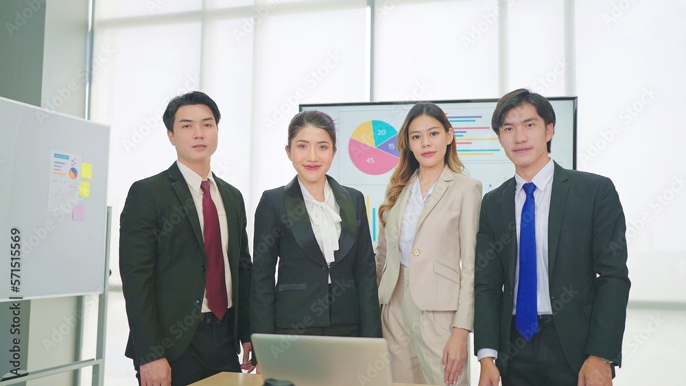 A group of young professional asian business people wearing suit standing and looking at camera A group of young professional asian business people wearing suit standing and looking at camera