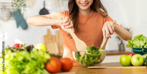 Portrait of beauty body slim healthy asian woman having fun cooking and preparing cooking vegan food healthy eat with fresh vegetable salad in kitchen at home.Diet concept.Fitness and healthy food