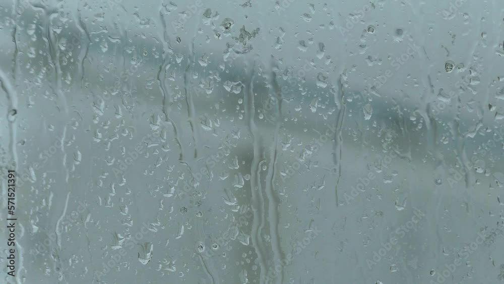 Drops of water run down the glass.  Snow falls on the glass and melts