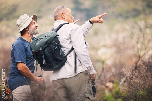 Hiking, pointing and senior men in nature for travel, walking and on a backpack adventure in Spain. Search, view and elderly friends doing bird watching and looking at environment in the mountains