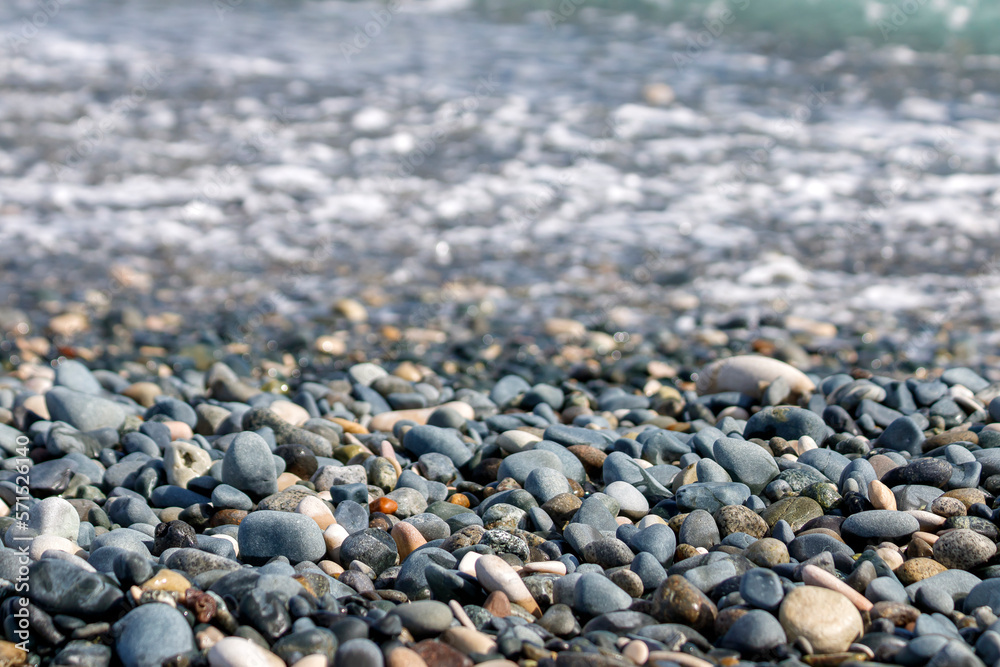 Beach stones and pebbles in front of blurry sea water Beach stones and pebbles in front of blurry sea water