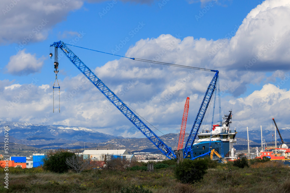 View of cranes and other port equipment in front of snowy mountains and cloudy sky, Limassol New Port, Cyprus View of cranes and other port equipment in front of snowy mountains and cloudy sky, Limassol New Port, Cyprus