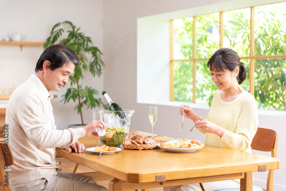 休日にシャンパンを飲み昼食する中高年夫婦 休日にシャンパンを飲み昼食する中高年夫婦