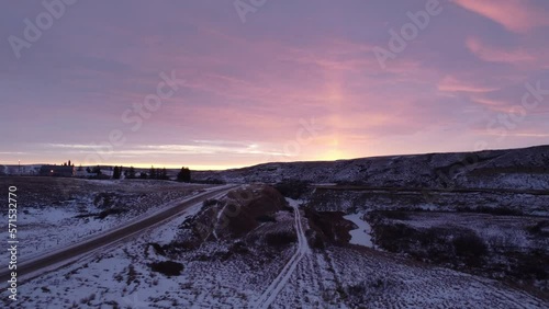 Aerial view along an old railway bed in a badlands coulee at Sharples, Alberta as the morning sun lights up the clouds. photo