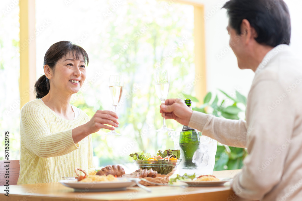 休日にシャンパンで乾杯する中高年夫婦
