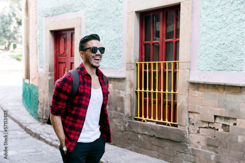 Mexican student in Guanajuato city, exploring a colorful village with a checked shirt. 