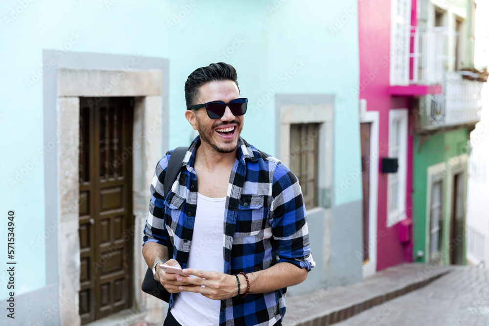 Fototapeta premium Mexican student in Guanajuato city, exploring a colorful village with a checked shirt. 