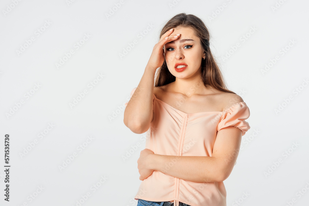 Unhappy frustrated woman frowns face, touches head, shows white teeth, expresses negative feelings. Lady regrets something in dissatisfaction. Concept of problems and headache Unhappy frustrated woman frowns face, touches head, shows white teeth, expresses negative feelings. Lady regrets something in dissatisfaction. Concept of problems and headache