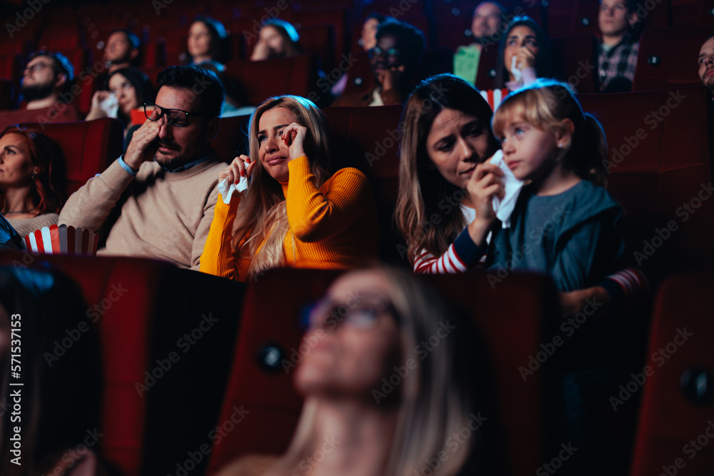 People watching sad movie in theater.