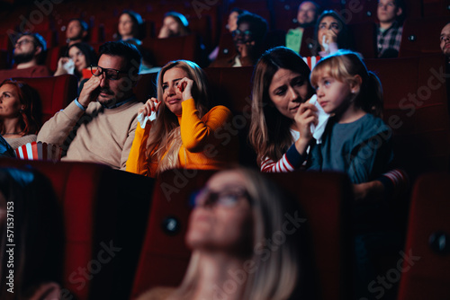 People watching sad movie in theater.