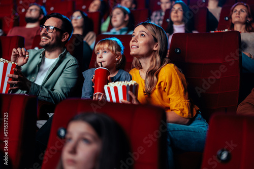 Family enjoying movie in theater.