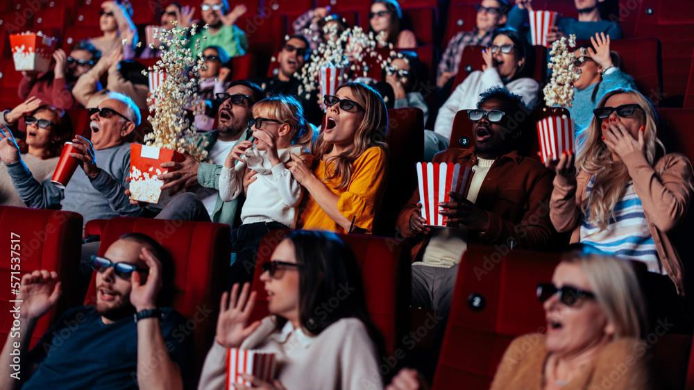 Scared people in movie theater.