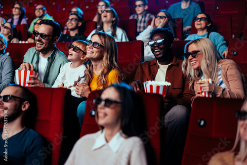 Excited crowd watching 3D movie in theater.