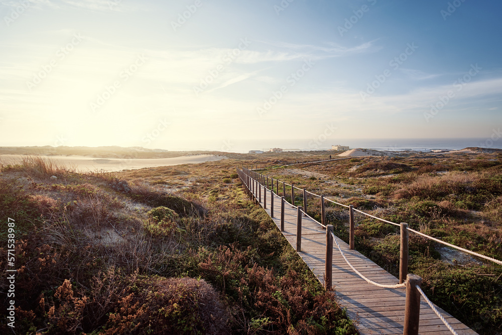 Fototapeta premium Wooden pedestrian walkway through Sintra-Cascais natural park. Wild sandy landscape, with part of Cresmina Dunes. Beautiful scenery in Portugal.