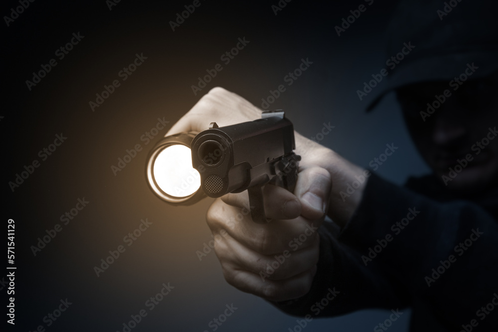 Professional security guard or policeman with flashlight and gun in dark room Professional security guard or policeman with flashlight and gun in dark room