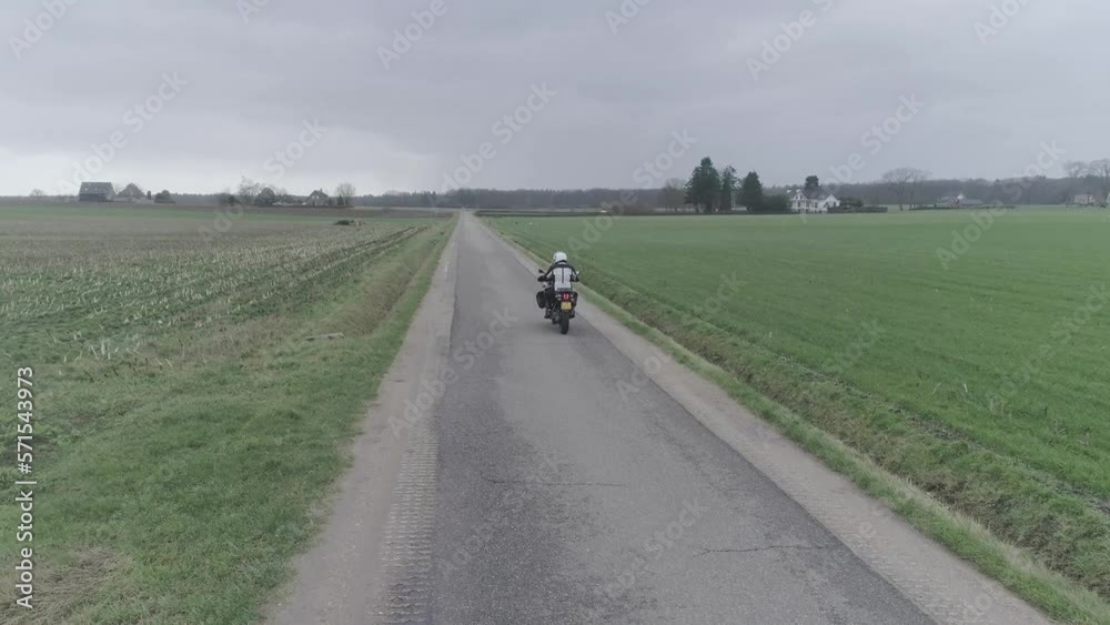 Motorcycle driving along farm fields. Motorcycle driving along farm fields.