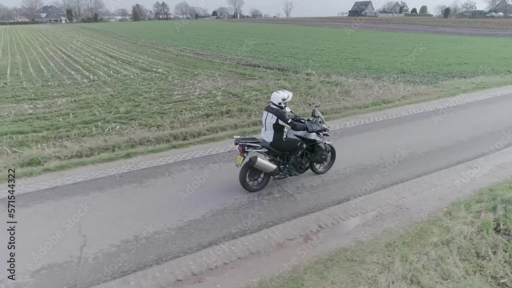 Drone following motorcyclist driving down farm field roads. Drone following motorcyclist driving down farm field roads.