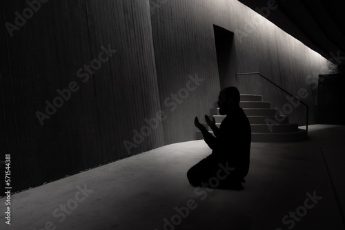 Islamic photo. Praying muslim man with raising hands in a mosque