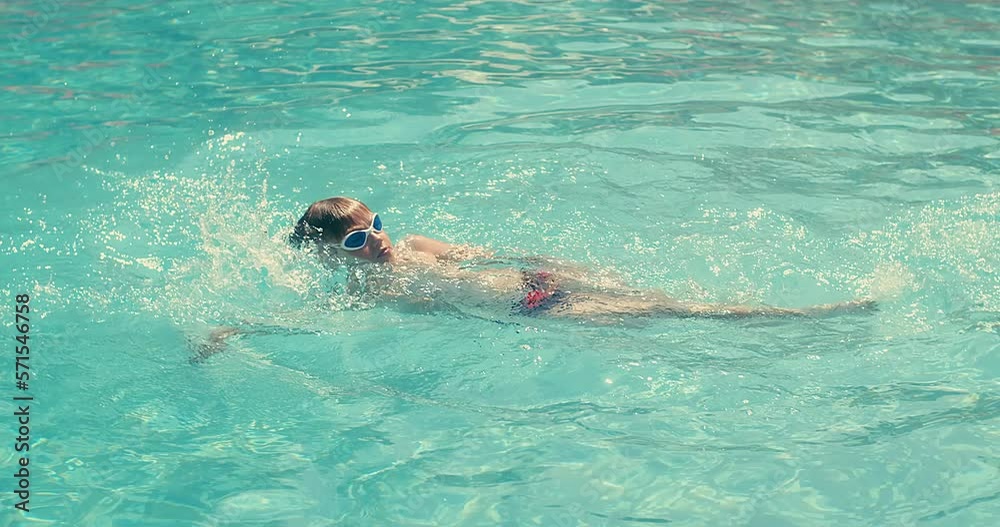 Child swim in the pool, sunbathes, swimming in hot summer day. Relax, Travel, Holidays, Freedom concept. 4K slow motion Child swim in the pool, sunbathes, swimming in hot summer day. Relax, Travel, Holidays, Freedom concept. 4K slow motion