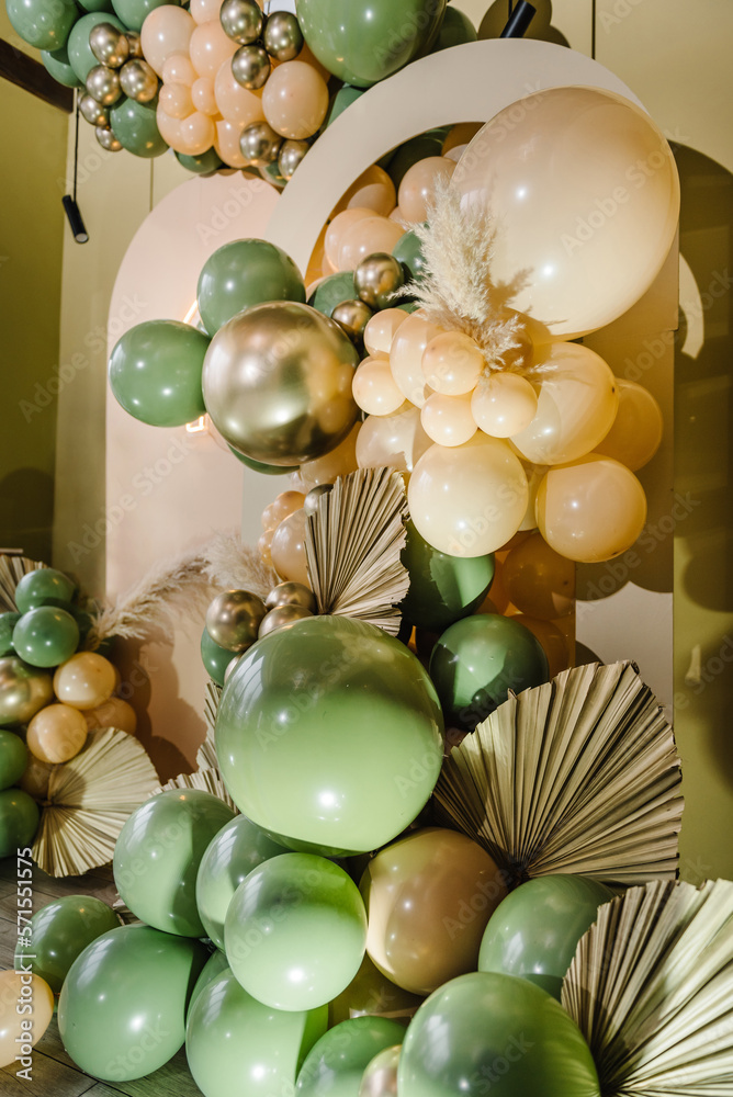 Arch decorated green, brown golden balloons, big paper decor leaves for  wedding ceremony. Celebration baptism concept. Trendy autumn decor, photo  wall. Copy space for text. Reception at birthday party Stock Photo