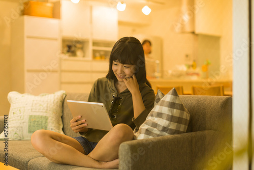 ソファーに座りタブレットPCを見る女の子