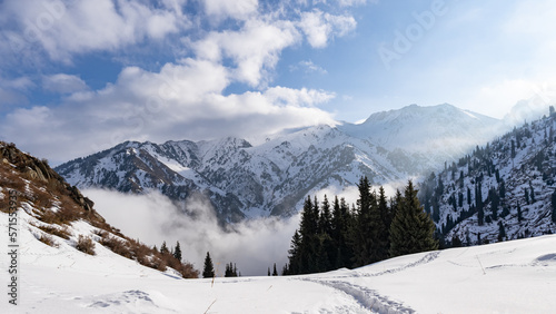 Cloudy weather. Mountain snow peaks in the clouds. Misty Mountains