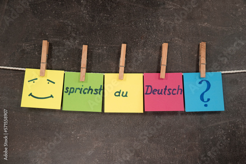 Napis w języku niemieckim Czy mówisz po niemiecku na kolorowych karteczkach zawieszonych na sznurku na ciemnym tle. Koncepcja nauki języka