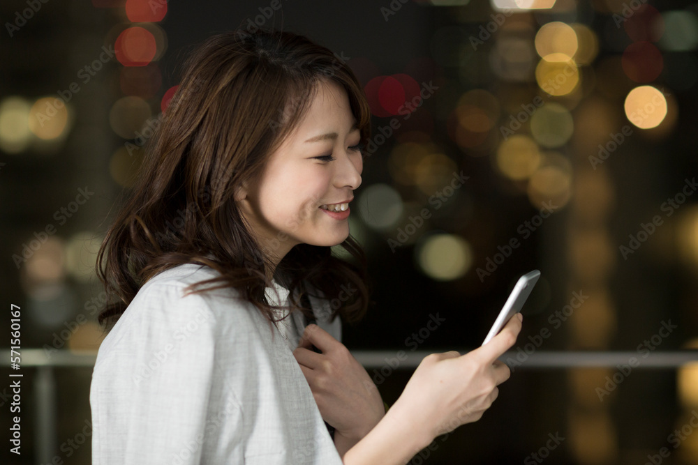 スマートフォンを見て笑顔のビジネスウーマン スマートフォンを見て笑顔のビジネスウーマン