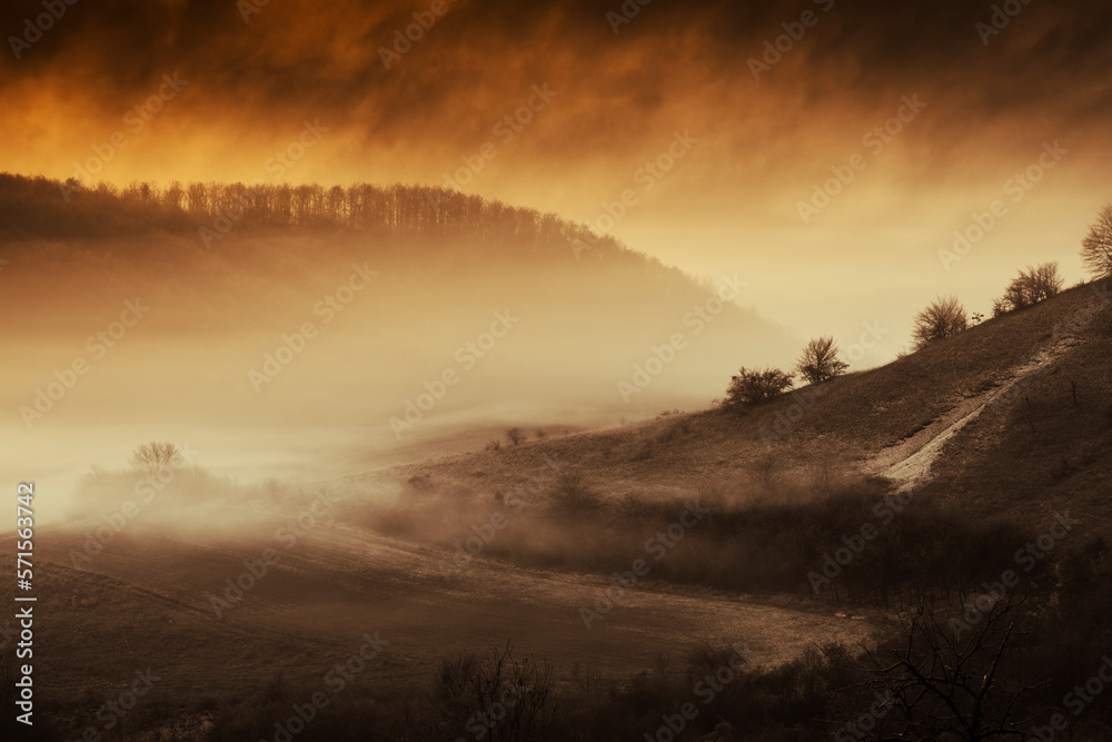 Obraz premium dramatic landscape with storm clouds over hills at sunset