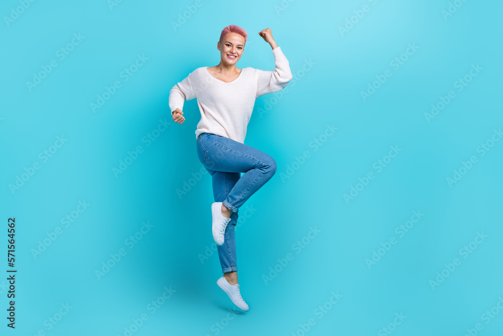 Full length size cadre of jump air champion competition girl wear white pullover raise fists up celebrate victory isolated on cyan color background Full length size cadre of jump air champion competition girl wear white pullover raise fists up celebrate victory isolated on cyan color background