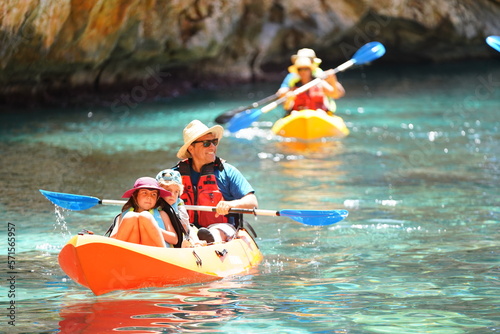 Photography Smiling man hiking family father with children sailing and paddling kayak in sea water during sunset