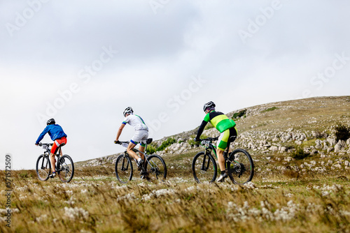 group athletes mountain bikers riding mountain trail race