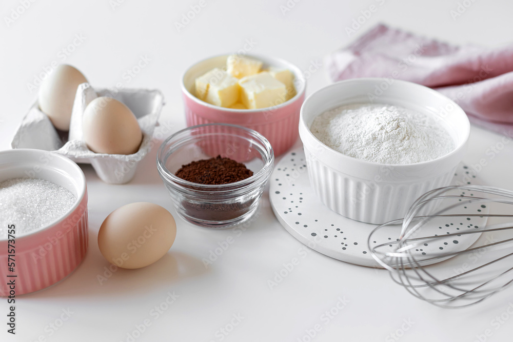 ingredients for baking chocolate cake on white table with kitchen utensils. closeup ingredients for baking chocolate cake on white table with kitchen utensils. closeup