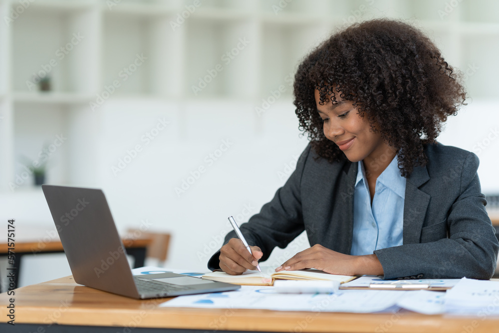 Positive successful african american woman, manager, CEO, sitting in the office at a laptop talking video call with client or employee discussing business strategy and ideas analyzed together Positive successful african american woman, manager, CEO, sitting in the office at a laptop talking video call with client or employee discussing business strategy and ideas analyzed together