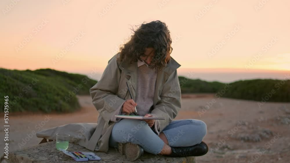 Creative girl drawing sketch at evening ocean mountain. Focused woman painting Creative girl drawing sketch at evening ocean mountain. Focused woman painting