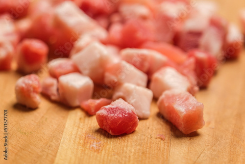 Diced Bacon on a wooden cutting board, close up.