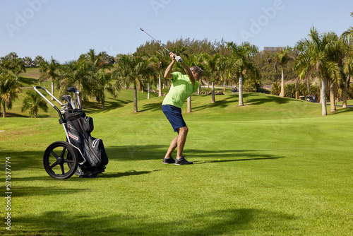 Golfer on a golf course, ready to tee off. Golfer with golf club hitting the ball for the perfect shot.