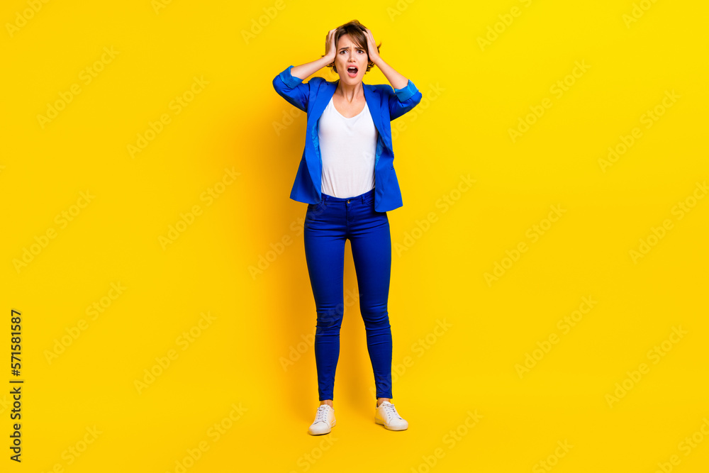 Full length photo of shocked amazed lady dressed blue blazer open mouth arms head isolated yellow color background Full length photo of shocked amazed lady dressed blue blazer open mouth arms head isolated yellow color background