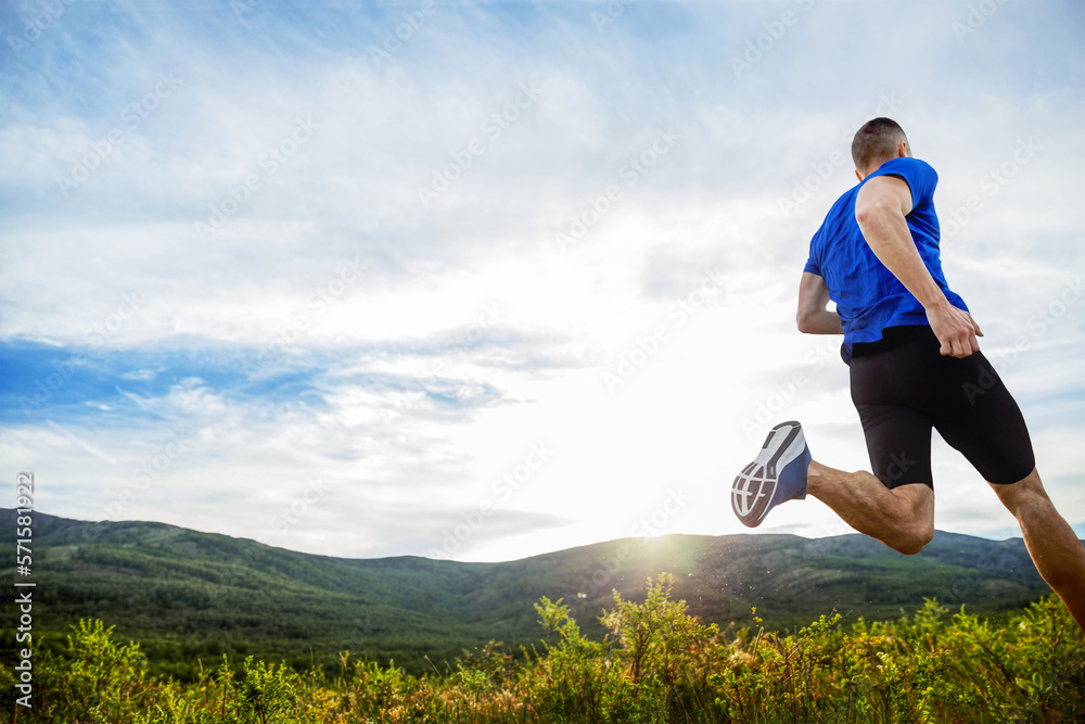 back athlete runner run mountain meadow in rays of sunset