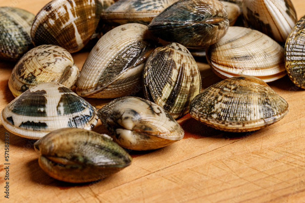 Close up of a cutting board with clams on top
