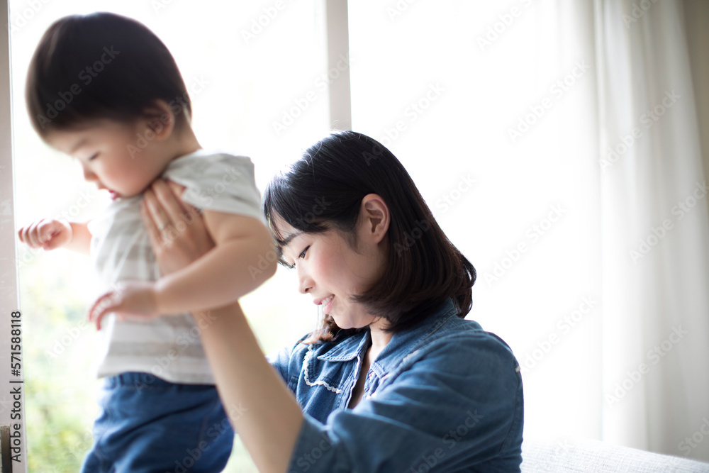 日当たりの良いリビングで椅子に座りくつろぐ母親と膝の上に座る小さな男の子 日当たりの良いリビングで椅子に座りくつろぐ母親と膝の上に座る小さな男の子