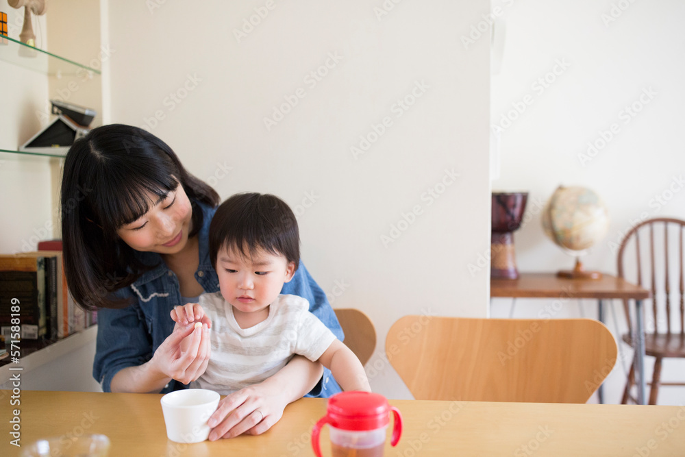 ダイニングテーブルで子供におやつを食べさせようとする母親 ダイニングテーブルで子供におやつを食べさせようとする母親
