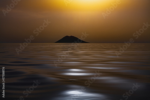 The volcanic island of Stromboli in the silvery Mediterranean Sea at sunset