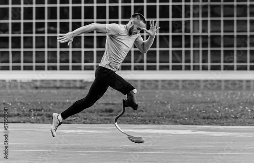 disabled athlete on prosthesis running black and white photo