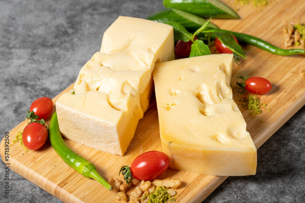 Gruyere cheese. Piece of Gruyere cheese on wooden cutting board. Cheese collection Gruyere cheese. Piece of Gruyere cheese on wooden cutting board. Cheese collection